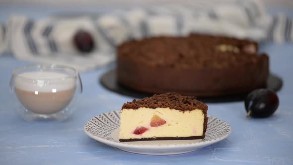 Piece of Delicious Homemade Cheesecake with Plums and Chocolate Crumble