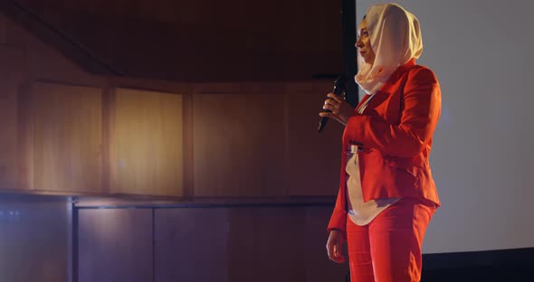 Businesswoman speaking on stage in auditorium 4k alt