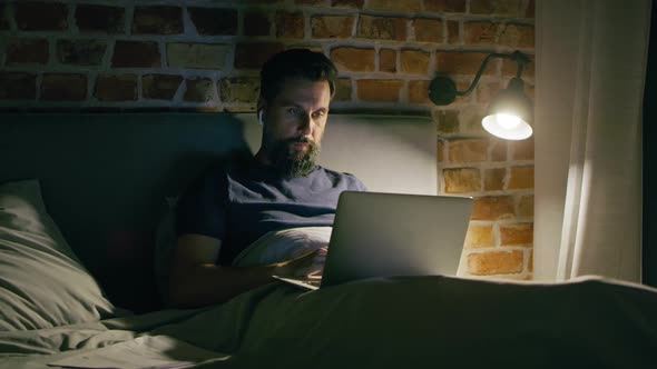 Video of man lying in bed during video conference. Shot with RED helium camera in 8K. alt