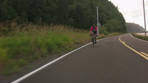 Tracking shot of a male cyclist on country road.  Fully released for commercial use.