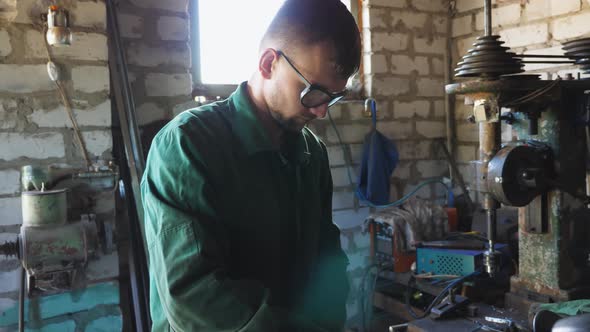 Close Up of Male Mechanic in Protective Eyewear Doing His Job at Workshop alt