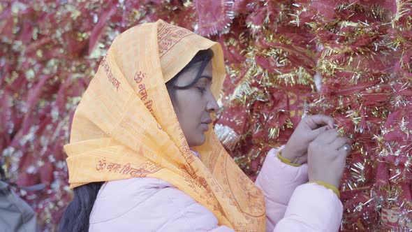 Indian Girl Tying Holy Sardine (Dupatta) at Kedarnath Temple