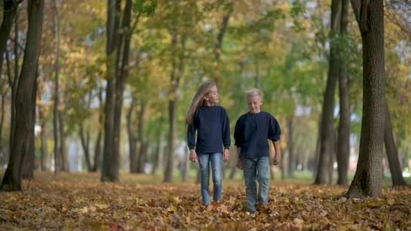Cute Little Children Walking in a Beautiful Autumn Park.