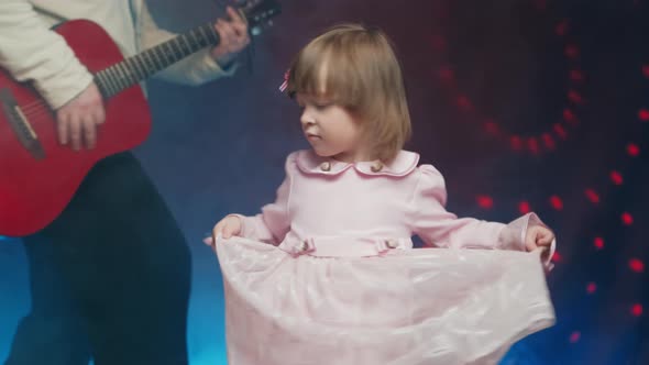 Llittle Girl in Vintage Dress Dances on Stage Her Father Plays Acoustic Guitar