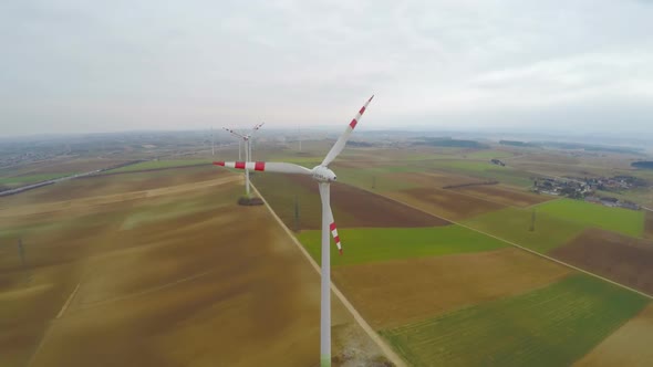 Wind Turbines Rotating on Green Field. Alternative Source of Energy. Aerial View alt