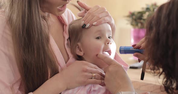 Young Woman Showing Her Little Scared Kid to Pediatrician