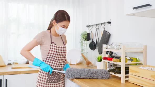 Asian cleaning service woman worker cleaning in kitchen room at home. alt