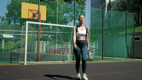 Young Athletic Blond Woman with Ponytail in Sportswear Walking at Sports Ground