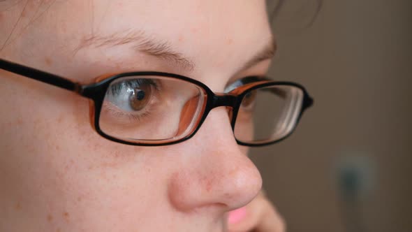Woman in Glasses Is Speaking Mobile Phone and Looking Ahead