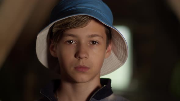 Portrait of a Serious Boy in a Blue Hat Looking at the Camera, Moving Camera, Indoors