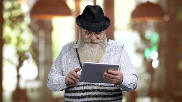 Old Retired Grandpa Talking with Someone Online Using Tablet Pc alt