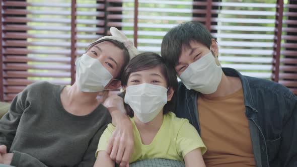 asian family stay home,happiness asian dad mom son wearing face mask sit relax smile together