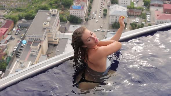 Attractive Woman in Swimming Pool on Roof