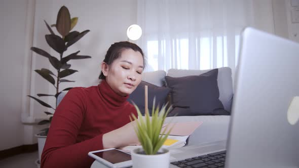 Businesswoman on redshirt using the laptop for meeting online and work from home alt