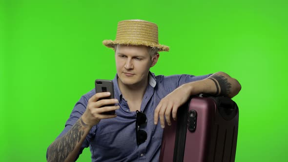 Portrait of Man Tourist with Suitcase Using Mobile Phone, Chatting. Chroma Key alt