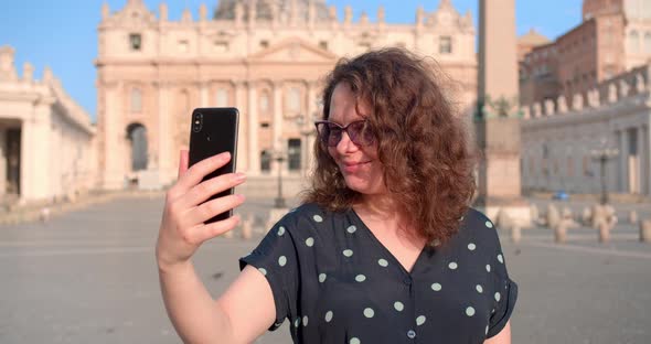 Young Caucasian female makes selfie in front of Vatican cathedral