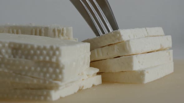 Taking piece of cow milk cheese from pile 4K footage alt