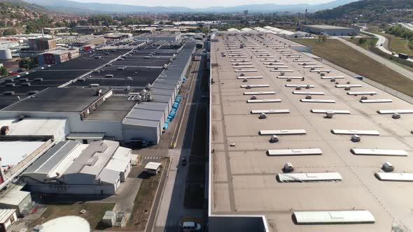 Big factory warehouse rooftop. Aerial drone shot camera flying forward-
