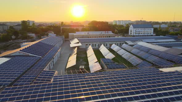 Aerial View of Solar Power Plant with Blue Photovoltaic Panels Mounted on Industrial Building Roof alt