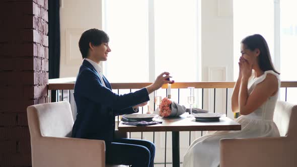 Beautiful Young Woman Is Excited About Marriage Proposal in Restaurant alt