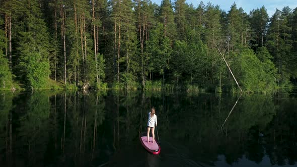 Woman Paddle Over The Lake With SUP Board