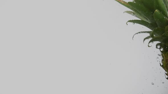 Tropical Fruit Pineapple Falling Into Water Right Side Splash and Air Bubbles on White Background alt