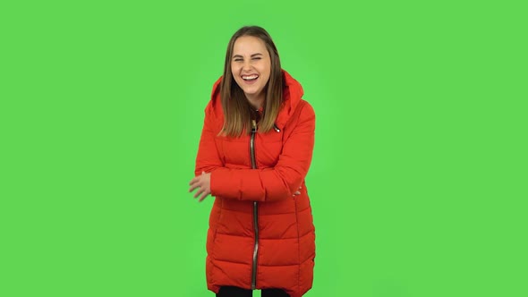 Lovely Girl in a Red Down Jacket Is Laughing. Green Screen alt