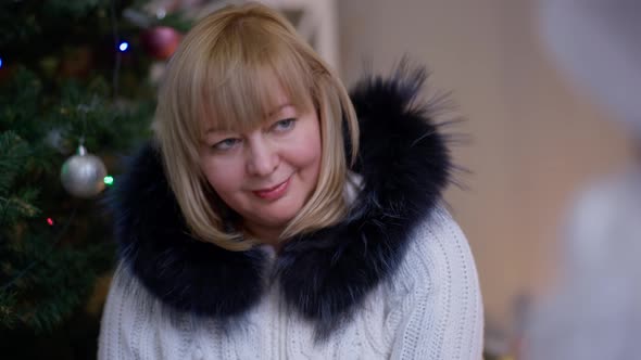 Closeup Portrait Cheerful Caucasian Woman Gesturing Victory Gesture Sitting at Christmas Tree at alt