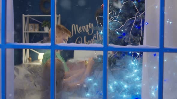 Siblings Decorating Spruce Christmas Tree alt