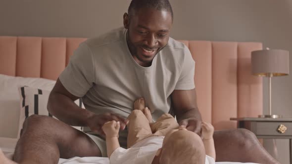 Dad Playing with Legs of Toddler alt