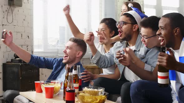 Friends taking selfie photo while cheering sport team