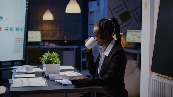 Workaholic African American Businesswoman Analysing Marketing Statistics on Paperwork alt