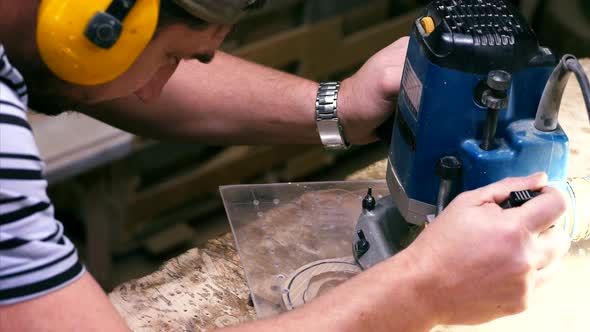 Male Carpenter Working with Milling Machine for Cutting Figure Wooden Detail alt