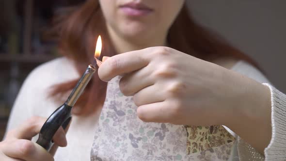 Girl Processes Edges of Fabric with Fire of Lighter