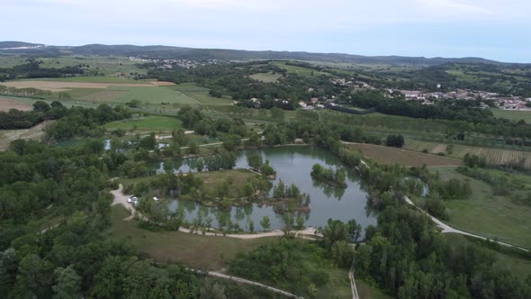 Aerial View of a Field and a Small Lake and Village in the South of France alt