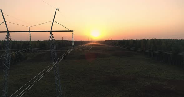 High Voltage Power Lines and Metal Pylon Tower Aerial View at Sunrise
