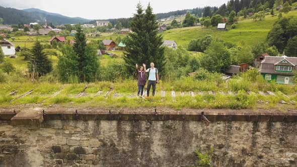 A couple walks along the old viaduct in the mountains Ukrainian Carpathians alt
