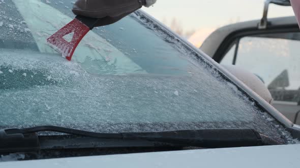 Closeup of Scraping Ice Off a Car Windshield alt