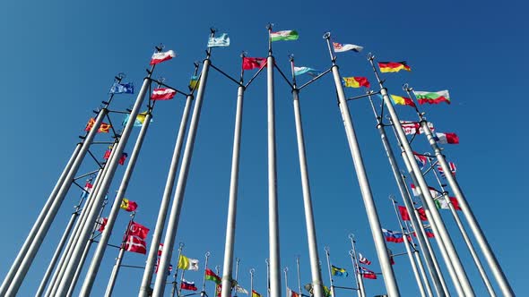 National Flags of Different Countries on Flagpoles Against the Blue Sky