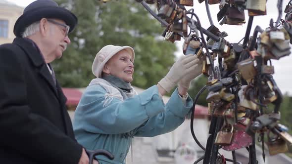 Old man shows wife locks of love. alt