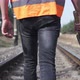 The railway worker walks along the railroad tracks, holding a sledgehammer in his hands. - VideoHive Item for Sale