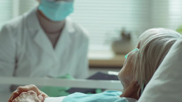 Senior Woman Talking with Doctor during Coronavirus Treatment alt