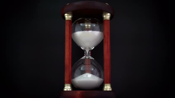 Rotating Hourglass On The Black Background. alt