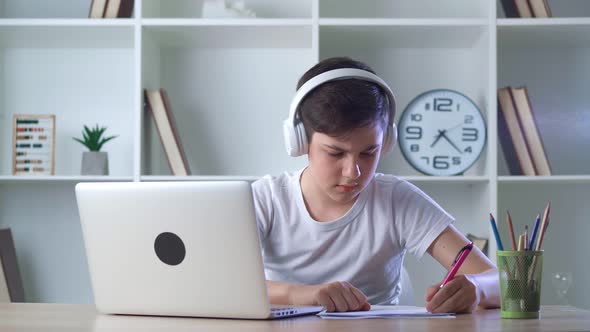 Pre Teen Cute Boy Pupil in Headphones Attending to Home Online School Class on His Computer Laptop alt