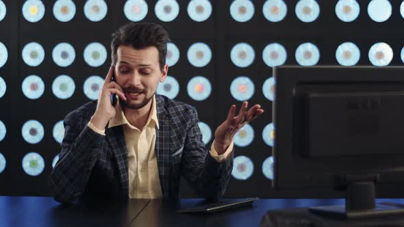 Goodlooking Businessman in Checkered Suit Actively Speaks to Partner on Phone