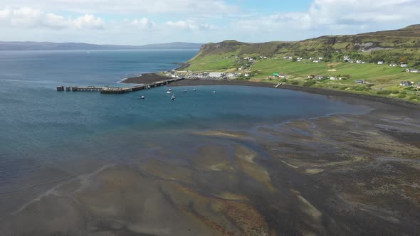 Aerial drone view of little harbour on the coast of Scotland on a sunny day