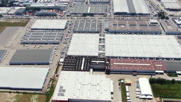 Aerial footage of a large shopping centre and car parks located in the city alt