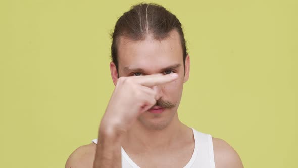Closeup Tenacious Man with Tied Hair Wants you Looking Into His Eyes Over Lemon Background Concept alt