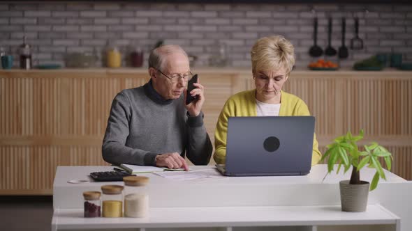 Retirees are Calculating Expenses Planning Budget and Calling to Bank Portrait of Old Spouses at alt