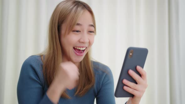 Excited Asian Woman having good news on phone